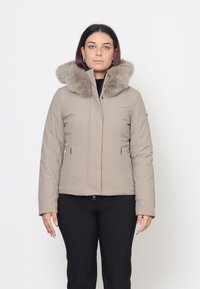 Giacca imbottita beige con cappuccio in pelliccia sintetica, due tasche laterali con zip, design aderente e superficie liscia. Chiusura con zip anteriore.
