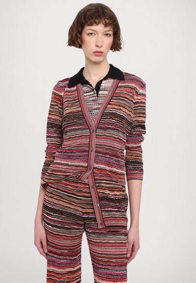 Cardigan a righe con colletto nero, caratterizzato da linee orizzontali in rosso, rosa, arancione e crema. Tessuto texture e chiusura con bottoni.