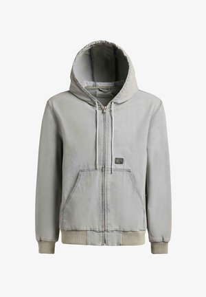 Helehall zipiga lukustatav kapuutsiga jakk, millel on ees taskud, nööriga kapuuts, soonilised mansetid ja väike ristkülikukujuline plaastriga rinnal.