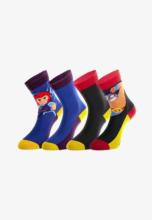 Quatre chaussettes montantes colorées avec des motifs de super-héros en dessin animé, présentant des accents rouges, bleus, noirs, jaunes et violets.