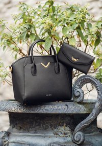 Black textured handbag with two handles and gold accents, featuring a smaller matching wallet, both displaying a brand logo.