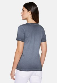 Gray short-sleeve T-shirt with a smooth texture, featuring contrast stitching at the hem and sleeves. Round neckline, relaxed fit.