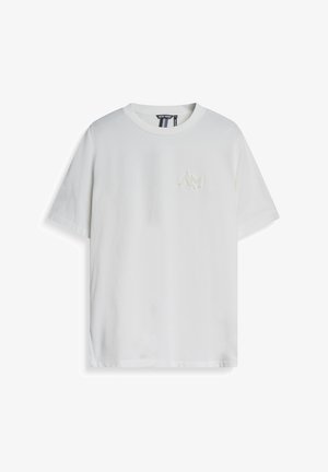 Witte katoenen t-shirt met korte mouwen, ronde hals en een klein, tonale logo op de linkerborst. Zachte textuur, casual pasvorm.