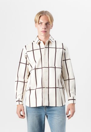 Beige button-up shirt featuring brown grid patterns, long sleeves, and a chest pocket, made of a soft fabric with a smooth texture.