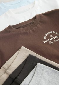 Assorted crewneck sweatshirts in brown, blue, white, gray, and beige. Features ribbed necklines and a logo on the brown sweatshirt.