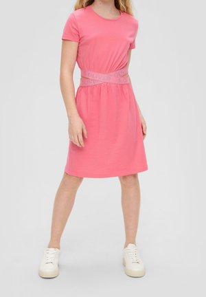 Vestido corto de algodón rosa con escote redondo, mangas cortas y cinturilla elástica con un logo, combinado con zapatillas blancas.