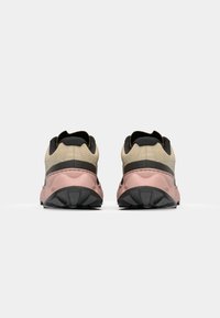 sportieve schoenen met een beige en zwarte bovenkant, een roze tussenzool en een gemarmerde rubberen buitenzool, met een gewatteerde kraag en een stevige hak.