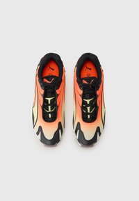 Baskets de sport orange et jaune avec des accents noirs, dotées d'un dessus texturé, d'un système de laçage et d'un logo Puma bien en vue sur la languette.