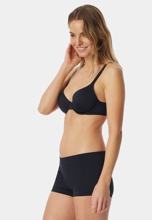 Soutien-gorge rembourré noir avec bretelles réglables et shorty noir assorti. Tissu lisse avec un design sans coutures et sans matériel visible.