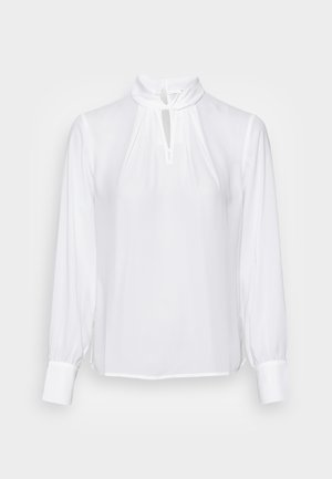 Blusa blanca de manga larga, con cuello alto y detalle de ojal en el escote. Fabricada con un tejido suave y ligero con acentos fruncidos.
