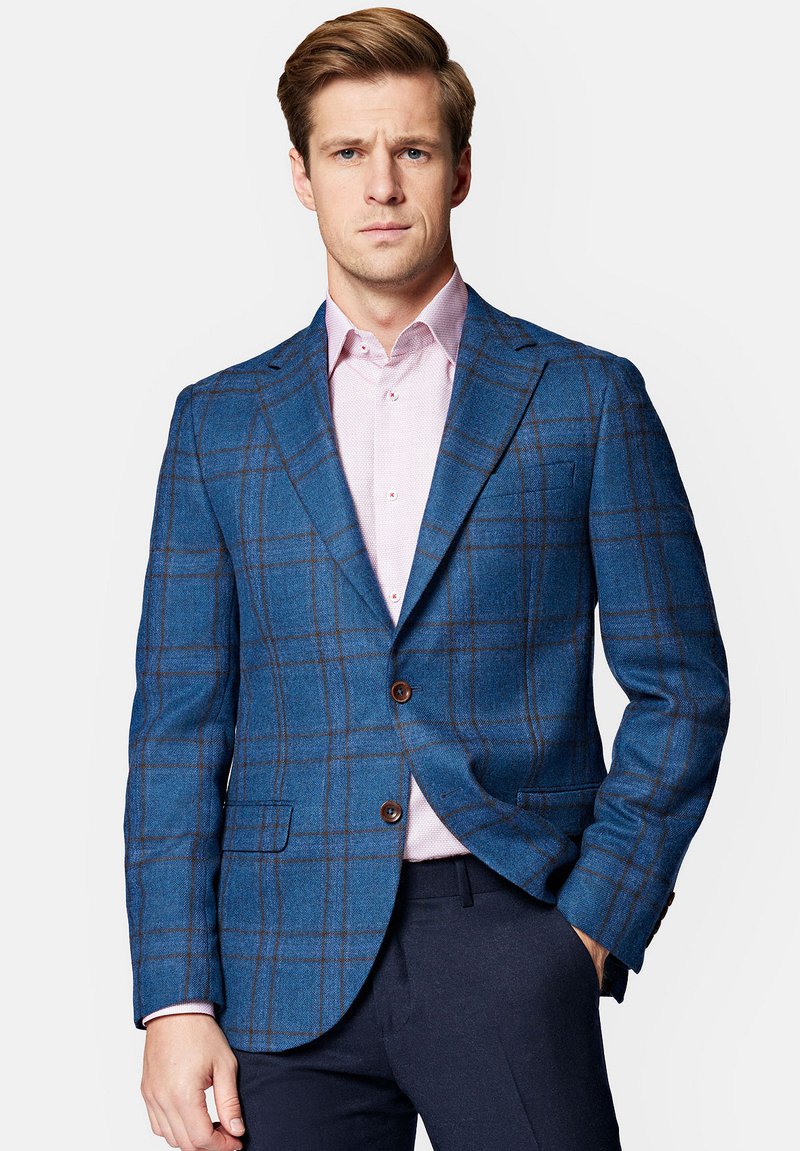 Niebieska marynarka w kratę, wykonana z wełny, z brązowymi akcentami, wyłogami i dwoma przednimi kieszeniami; nałożona na jasnoróżową koszulę.