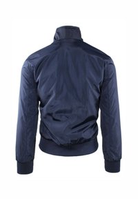 Giacca bomber blu navy, realizzata in tessuto liscio e lucido. Presenta un colletto alla coreana, polsini e vita a costine. Senza chiusure visibili.