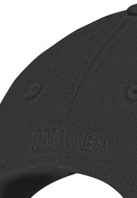 Casquette de baseball noire avec texte brodé en relief "JOHNNY URBAN" sur le panneau avant, montrant la texture du tissu et les détails des coutures.