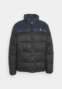 Zwarte gewatteerde jas met een marineblauwe bovenpaneel, hoge kraag en ritssluiting aan de voorkant. Voorzien van een logopatch op het linkerborstgebied.