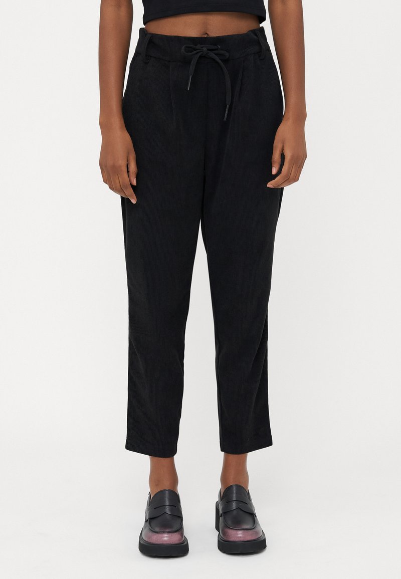 Black corduroy trousers with a drawstring waist, straight leg design, and subtle texture. Pants feature front pleats and a relaxed fit.