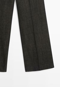 Dark denim trousers with a straight cut, featuring subtle texture and prominent seams, offering a classic and versatile design.