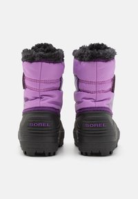 Violet ziemas zābaki ar mīkstu melnu mākslīgās kažokādas apkakli, gumijas zoli un Sorel zīmolu. Pildīts augšdaļa siltumizolācijai.