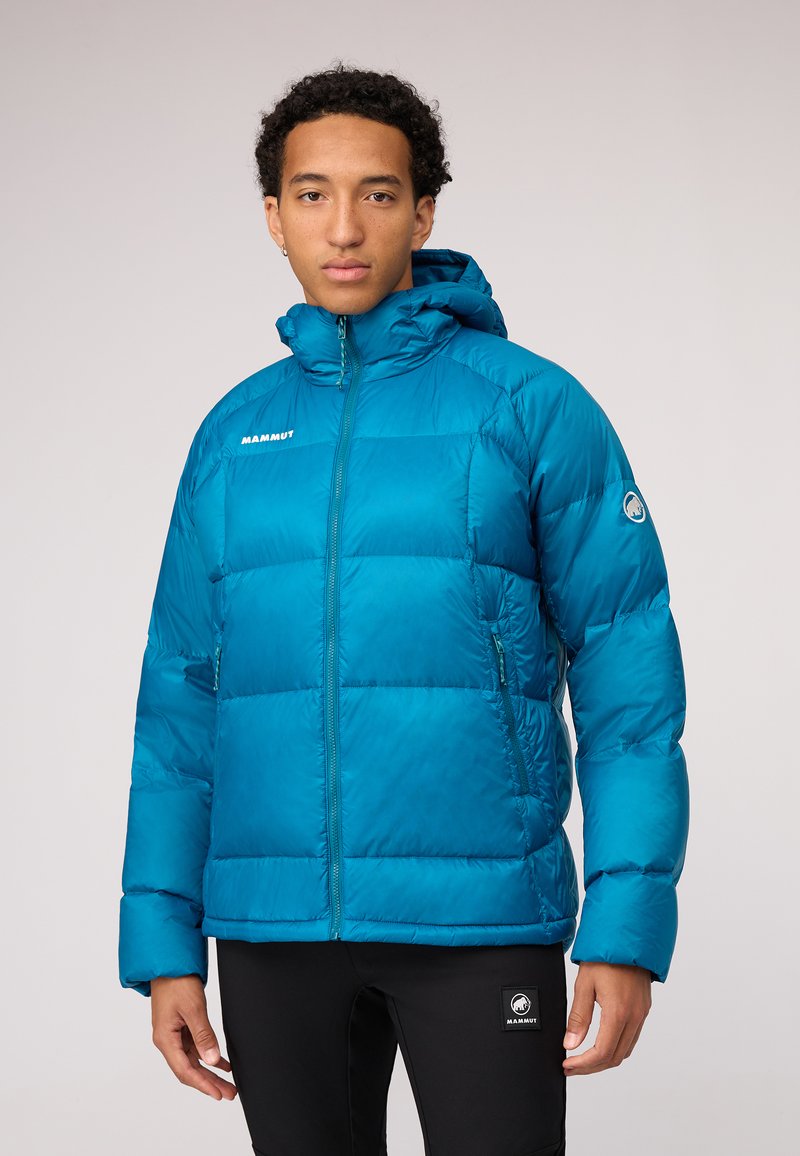 Blue insulated puffer jacket with a hood, featuring a front zipper, elastic cuffs, and logo on the left chest. Smooth, shiny texture.