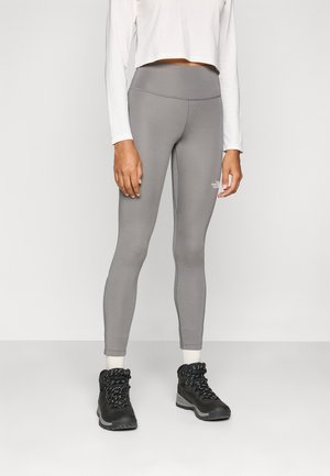 Grå leggings med høy midje og sømløst design, paret med svarte tursko med tykke såler og snøring.