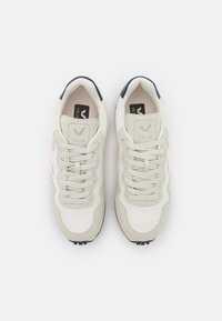 Ljust grå sneakers med rosa detaljer, mesh- och mockamaterial, rund tåform och platta snören. Svart gummisula.