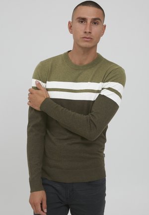 Olivgrüner Pullover mit weißen und dunkelgrünen Streifen über der Brust, rundem Halsausschnitt sowie gerippten Bündchen und Saum. Weiches, strukturiertes Strickmaterial.