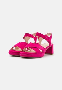Roze suède hoge hakken sandalen met een blokhak, voorzien van kruislings gespen en een enkelgesp voor een verstelbare pasvorm. Glad voetbed.