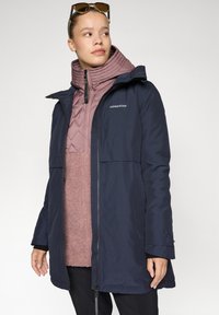 Ναυτικό αδιάβροχο παλτό με κουκούλα πάνω από ελαφρύ ροζ επενδυμένο εσωτερικό στρώμα. Με φερμουάρ μπροστά, πλαϊνές τσέπες και υφασμένο υλικό.