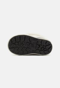 Suela de goma negra con un patrón de taqueado en zigzag. Parte superior de color claro con un acabado texturizado, que proporciona agarre y estabilidad.