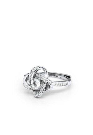 Zilveren ring met een centrale ronde diamanten, omringd door een ingewikkelde knoop van kleinere diamanten op een smalle, met diamanten bezette band.