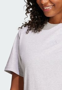 Gray cotton t-shirt with short sleeves, featuring an embossed logo on the chest. Soft texture and relaxed fit.