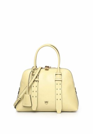 Crèmekleurige leren handtas met dubbele handvatten, verstelbare schouderriem, gespsdetails aan de voorkant en klein metalen logo middenvoor.