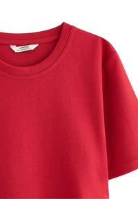 Rød bomulds t-shirt med rund halsudskæring og korte ærmer. Glat tekstur med et enkelt, ensfarvet design. Etikette i nakken.