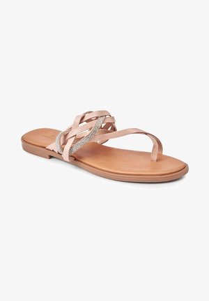 Sandale plate de couleur rose poudré avec des brides croisées ornées d'un accent en strass. Semelle marron lisse, design minimaliste, et orteils découverts.