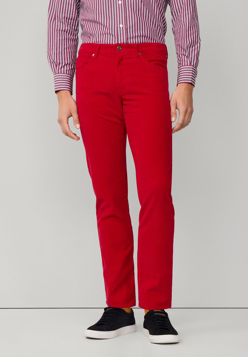 Rode katoen chino's met een slim fit, voorzien van een klassieke vijf-pocketontwerp en een knoopsluiting. Gecombineerd met zwarte sneakers.