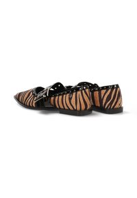Bailarinas con estampado de animal que presentan un patrón de rayas de tigre en marrón y negro. Correa negra mate con acentos metálicos. Diseño de suela baja y plana.