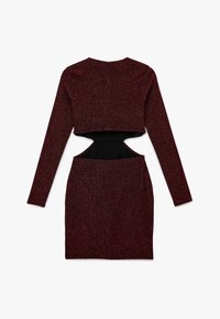 Vestido de tela con purpurina roja, mangas largas, top corto, abertura en la cintura y falda ajustada. Cierre con cremallera en la parte trasera.