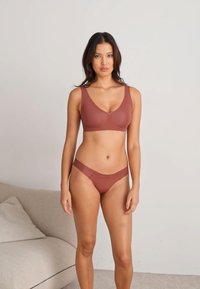 Brun BH og matchende truse laget av glatt stoff, med et minimalistisk design, scoop halslinje og sømløse kanter.