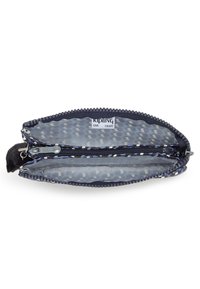 Portafoglio blu navy con zip, dotato di un morbido pom-pom nero, con un interno grigio a motivi, doppio scomparto e un'etichetta del marchio all'interno.