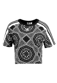 Svart och vit kortärmad crop top med geometriska mönster, rund halsringning samt kontrasterande vita sidostråk. Tillverkad av ett texturerat tyg.