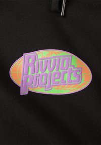 Sort stof med en stor, oval lappe. Lappen har teksten "Rivida Projects" i lilla med en grøn kant og orange detaljer, sat mod et globusdesign.