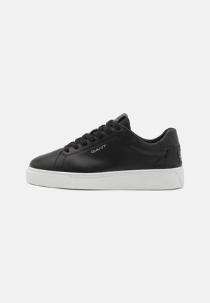 Black leather sneaker with white rubber sole. Features round toe, front lacing, and embossed logo on the side. Smooth texture.