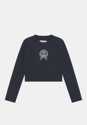 Marineblå cropped langærmet top lavet af bomuld med rund halsudskæring og et centralt broderet logo med et emblem og tekstdetalje.