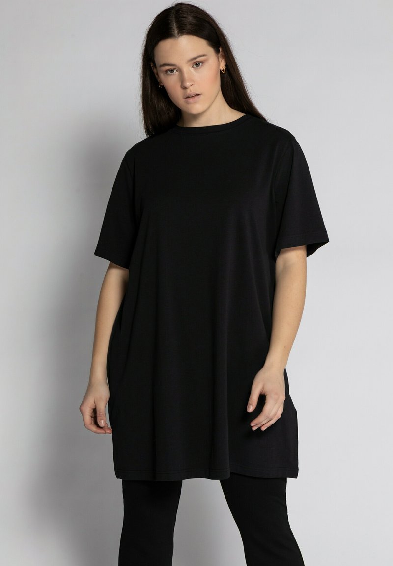 Black oversized t-shirt dress with short sleeves, round neckline, and soft, smooth texture. Features a relaxed fit and simple design.
