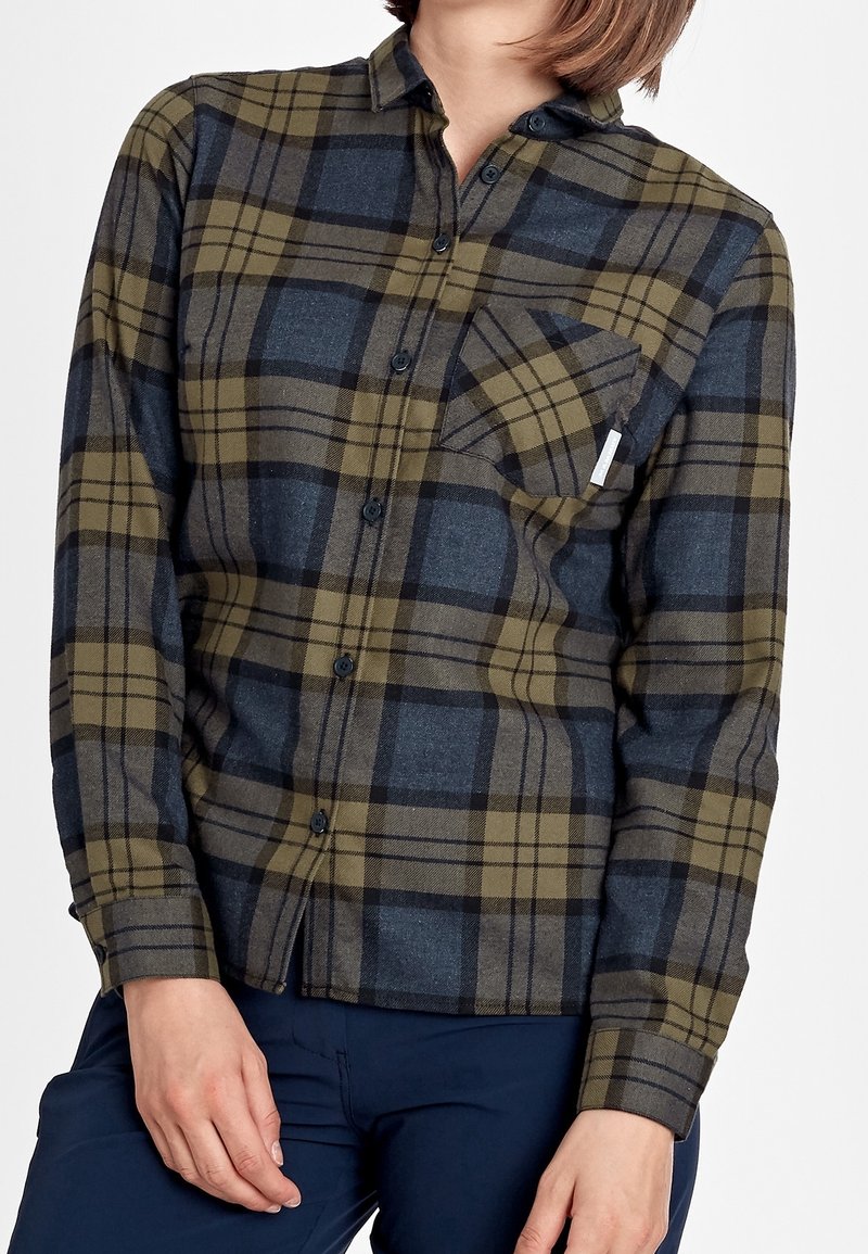 Rutigt flanellskjorta i nyanser av olivgrön och marinblå. Har krage med knappar, långa ärmar och en bröstficka med en etikett.