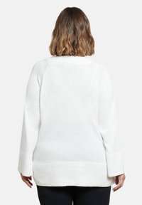 Maglione bianco a maglia con bordo e polsini a coste. Presenta un collo alto e una vestibilità leggermente oversize. Design pulito e semplice senza decorazioni.