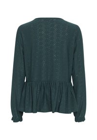 Dunkelgrünes Langarmoberteil mit Peplum-Design, das aufwändige Lochmuster, strukturierten Stoff und geraffte Ärmelbündchen aufweist.