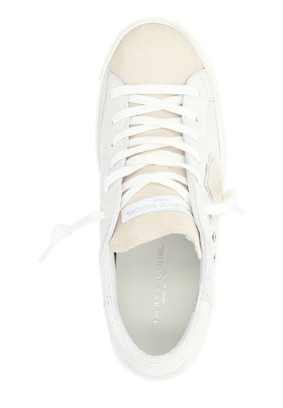 Sneaker bianco con punta in suede beige, corpo in pelle testurizzata, lacci bianchi piatti e marchio argento sulla linguetta.