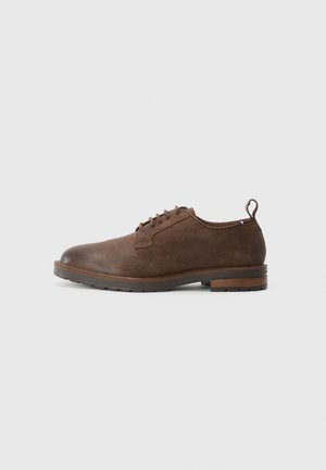 Brown leather dress shoe with a rounded toe, lace-up design, and a textured finish. Features a sturdy rubber sole and a small heel.