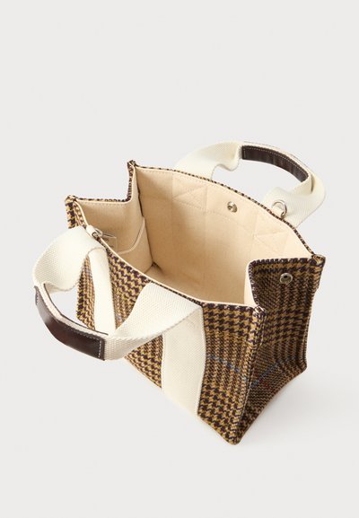 Petit sac fourre-tout rectangulaire avec un motif en houndstooth marron, anses en toile crème avec poignées en cuir, et intérieur en tissu beige ouvert.