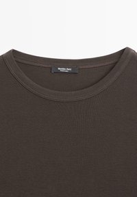 Brun bomulds t-shirt med en klassisk rund halsudskæring og glat tekstur. Mærket viser "Massimo Dutti" og "Fremstillet i Indien."